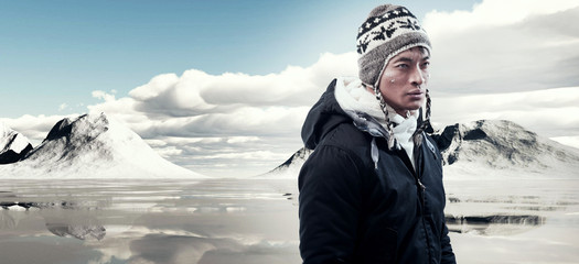 Asian winter fashion man in snow mountain landscape. Wearing bla