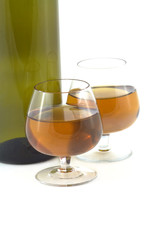 Two glasses with wine and part of green bottle isolated
