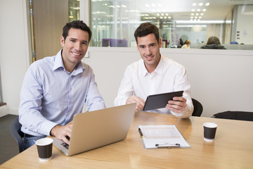 Fototapeta na wymiar Two casual businessmen working together in modern office