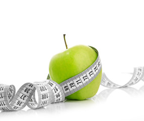 Measuring tape wrapped around a green apple