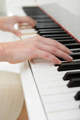 Fototapeta na wymiar Close up of hands playing piano