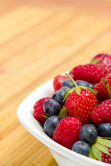 Close-up view of part of plate full of berries on the table