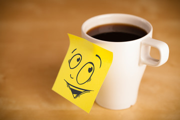 Post-it note with smiley face sticked on cup