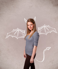 Young girl with devil horns and wings drawing