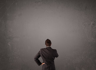 Businessman standing in front of an empty wall