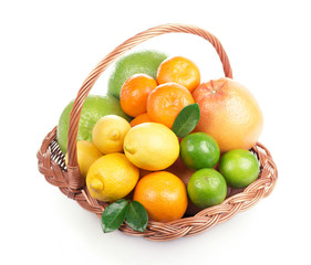 Fresh citrus fruit with leaves in a wicker basket close up