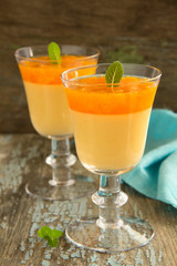 orange panna cotta with slices of oranges.
