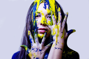 portrait of woman painted blue and yellow on white background