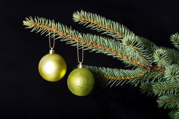 Two christmas balls hanging on a tree.