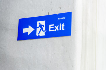 Blue exit sign on white wall