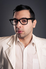 Obraz premium Portrait of young nerd with eyeglasses on grey background.