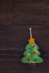 Christmas toy fir tree hanging over wooden background