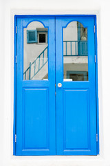 Fototapeta na wymiar Blue wooden door on white wall