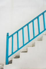Blue handrail with white stairs