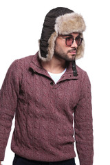 side view of a young casual man in furry hat