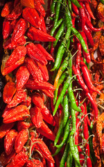 Red and green pepper in bunches above counter