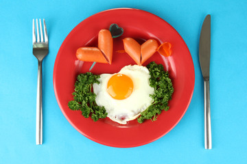 Sausages in form of hearts, scrambled eggs and parsley,