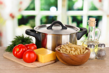 Ingredients for cooking pasta on table in kitchen