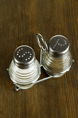 Salt and pepper mills, on wooden background