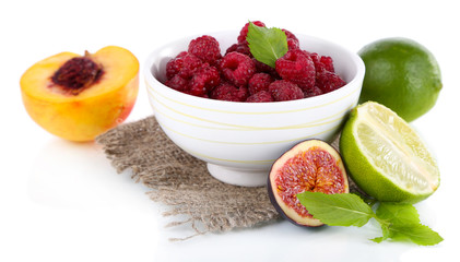Raspberries in small bowl on sackcloth isolated on white