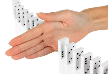 Hand stopping dominoes falling isolated on white