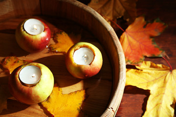 Composition with apples and candles in tub on wooden background