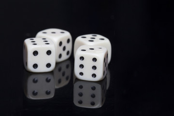 Four white dices in a black background