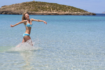 happy girl in bikini running seawater