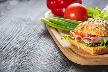 A fresh deli sandwich with ham, radish, tomatoes