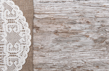 Old wood bordered by burlap and lacy cloth