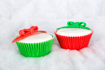 Different Christmas cupcakes on white snow background