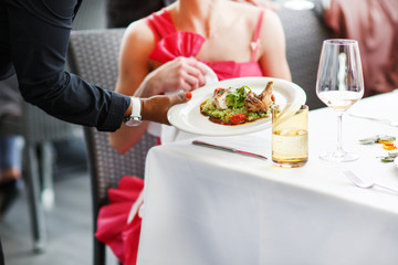 Waiter carrying a plate with salad dish on a wedding.