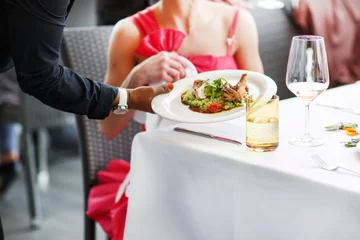 Fototapeten Waiter carrying a plate with salad dish on a wedding. © Irina Schmidt