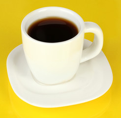 A cup of strong coffee on yellow background