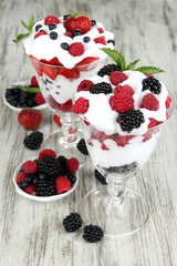 Natural yogurt with fresh berries on wooden background