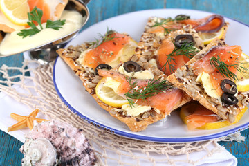 Salmon sandwiches on plate  on wooden table close-up