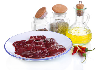 Raw liver on plate with spices and condiments isolated on white