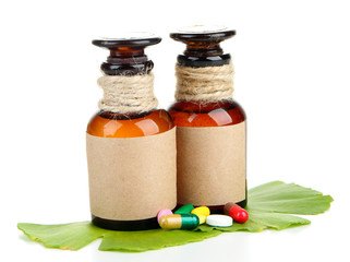 Ginkgo biloba leaves and medicine bottles with pills isolated