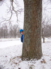 Child hidden behind a tree