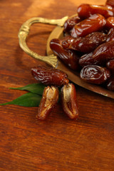 Dried dates on metal tray on wooden background