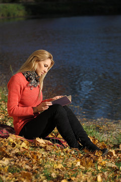 girl reading in autumn park