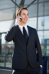 Happy businessman smiling and calling by cellphone