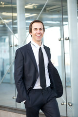 Fototapeta premium Portrait of a smiling businessman walking in the city