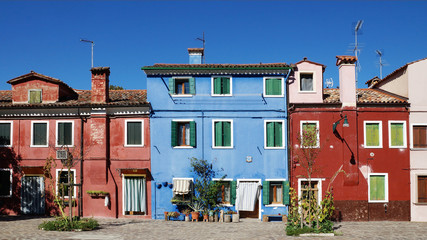 Fototapeta premium colored facade of the island of Burano in the background of blue