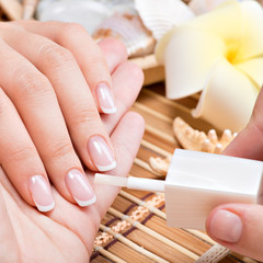 Woman in a nail salon receiving manicure