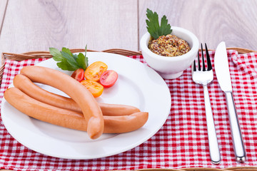 leckere wiener würstchen mit senf auf einem holztisch