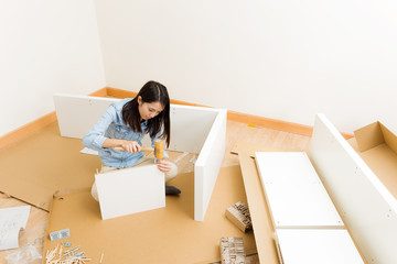 Asian woman assembling closet