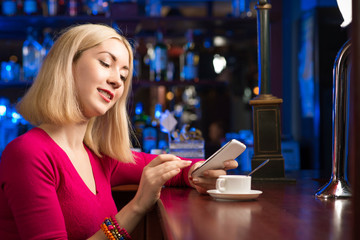 Fototapeta premium woman with a cup of coffee and cell phone