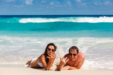 Fototapeta premium Young romantic couple laying on sandy beach