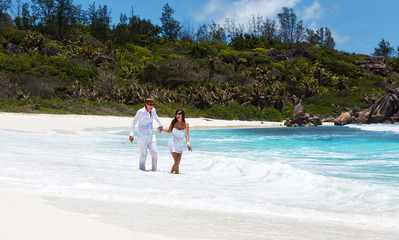 Young couple married laying on sandy beach